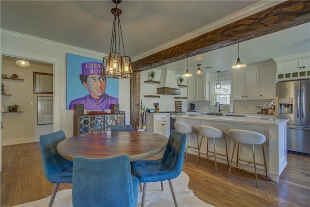 dining area with an inviting chandelier, crown molding, dark wood-type flooring, and sink