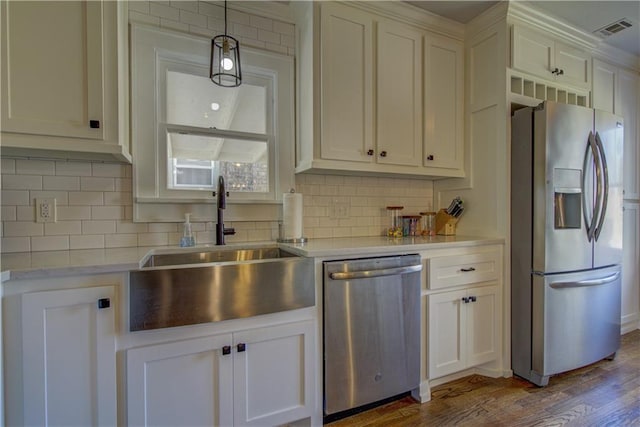 kitchen with decorative backsplash, dark hardwood / wood-style flooring, stainless steel appliances, sink, and white cabinets