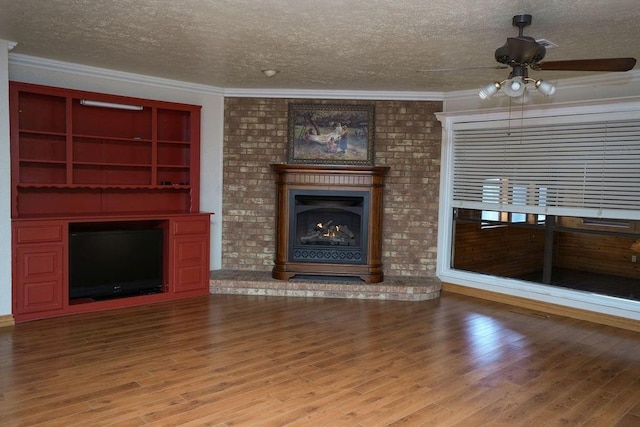 unfurnished living room with light hardwood / wood-style flooring, a fireplace, ornamental molding, and a textured ceiling