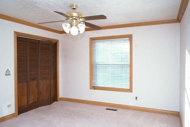 unfurnished bedroom featuring crown molding, ceiling fan, and a closet