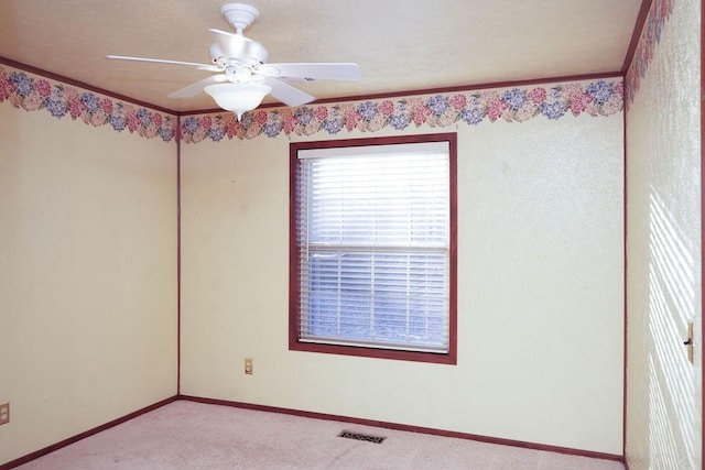 carpeted spare room with ornamental molding and ceiling fan