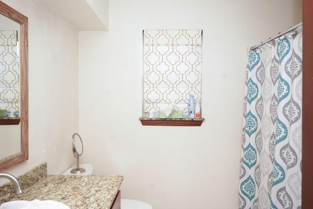 bathroom featuring vanity, curtained shower, and toilet