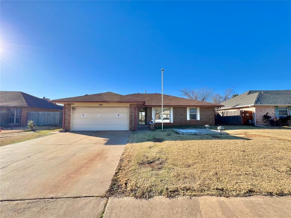 single story home with a garage and a front yard