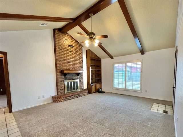 unfurnished living room featuring ceiling fan, lofted ceiling with beams, a brick fireplace, built in shelves, and light colored carpet