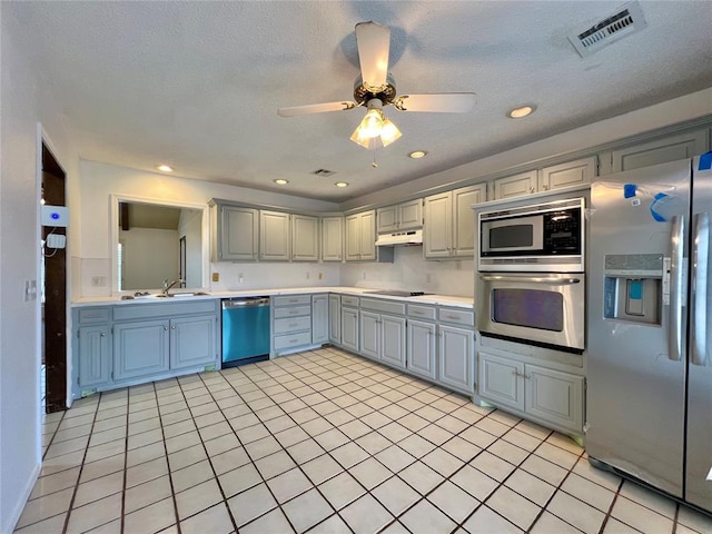 kitchen with sink, gray cabinets, ceiling fan, stainless steel appliances, and a textured ceiling