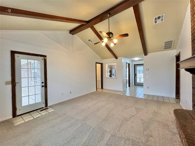 unfurnished living room with vaulted ceiling with beams, light colored carpet, a brick fireplace, and ceiling fan