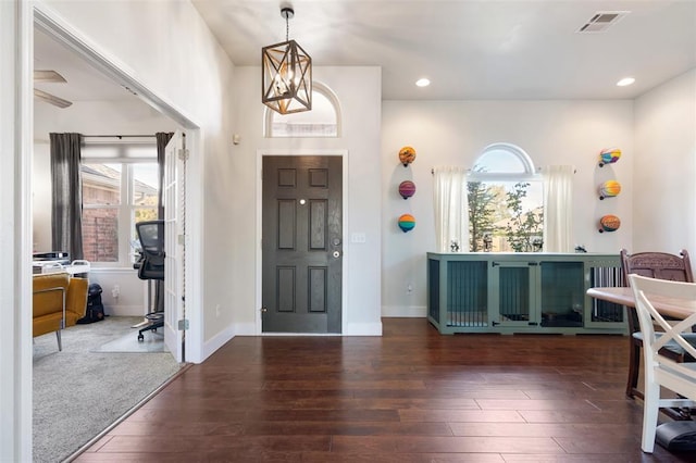 entrance foyer featuring plenty of natural light, a chandelier, and dark hardwood / wood-style floors