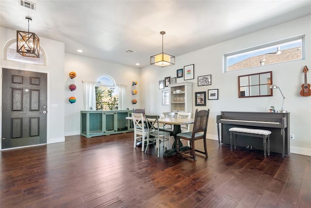 dining space with a notable chandelier and dark hardwood / wood-style flooring