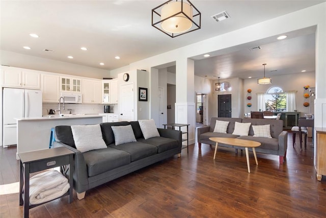 living room with dark hardwood / wood-style flooring and sink