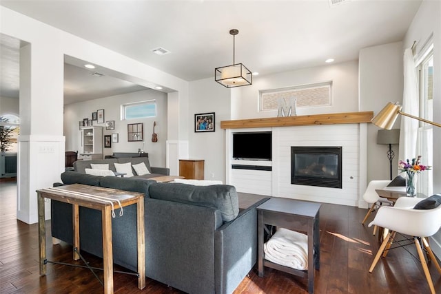 living room featuring a fireplace and dark wood-type flooring