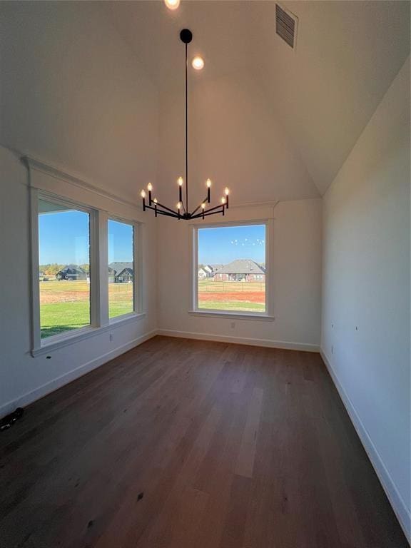 unfurnished dining area with dark hardwood / wood-style flooring, a chandelier, and vaulted ceiling