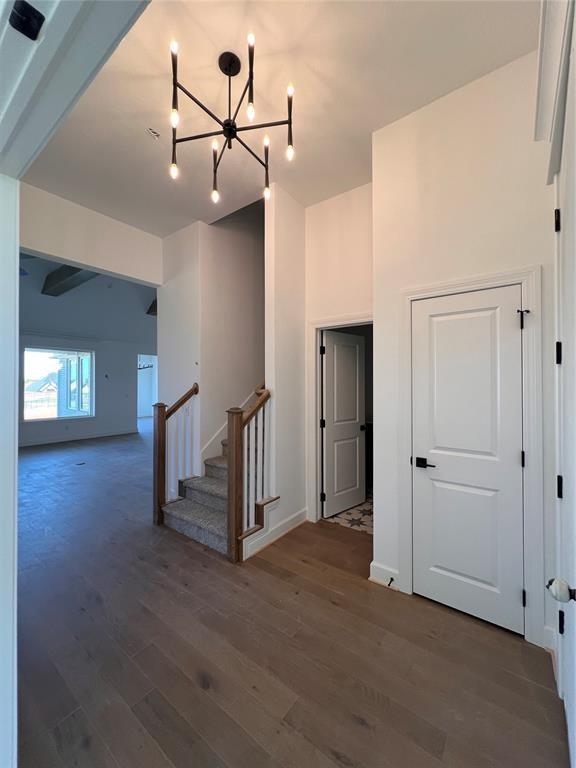 hall with dark hardwood / wood-style flooring and a notable chandelier