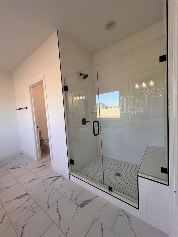 bathroom featuring toilet and an enclosed shower