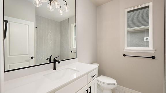 bathroom with toilet, baseboards, and vanity