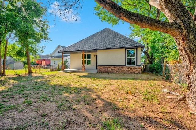 rear view of house with a lawn and central air condition unit