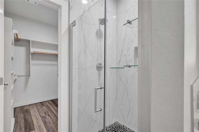 bathroom with hardwood / wood-style floors and a shower with shower door