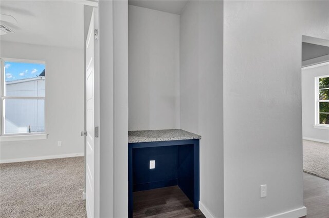 interior space featuring dark carpet and built in desk