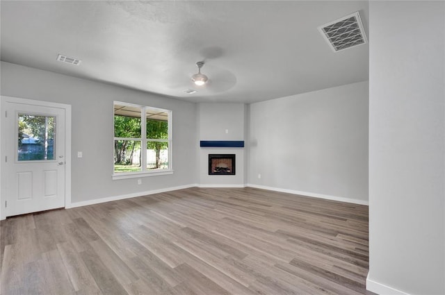 unfurnished living room with ceiling fan and light wood-type flooring