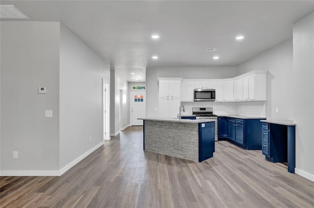 kitchen with decorative backsplash, white cabinetry, stainless steel appliances, and blue cabinets