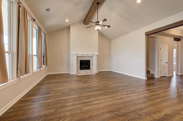 unfurnished living room with a fireplace, lofted ceiling with beams, ceiling fan, and dark wood-type flooring