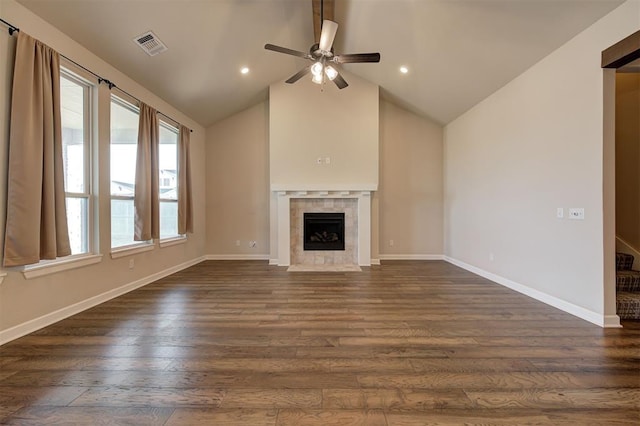 unfurnished living room with ceiling fan, dark hardwood / wood-style flooring, a tile fireplace, and vaulted ceiling