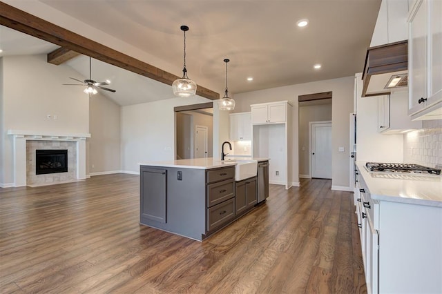 kitchen with a kitchen island with sink, white cabinets, sink, decorative backsplash, and appliances with stainless steel finishes