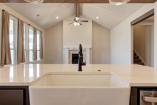 kitchen featuring ceiling fan, sink, and lofted ceiling with beams