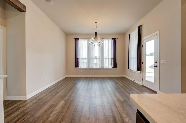 unfurnished dining area featuring dark hardwood / wood-style flooring and a chandelier