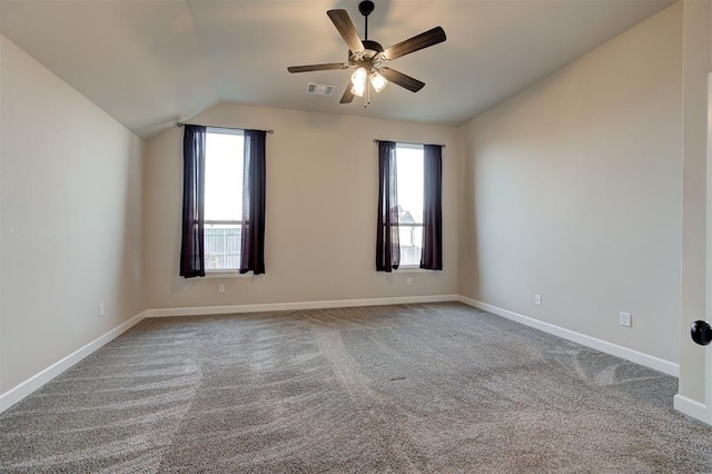 carpeted spare room featuring vaulted ceiling and ceiling fan