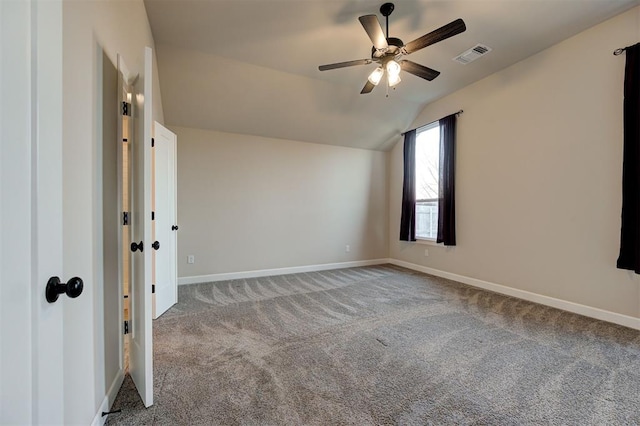 carpeted spare room featuring ceiling fan and vaulted ceiling