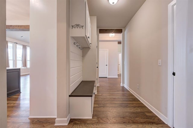 hallway with beamed ceiling and dark hardwood / wood-style flooring