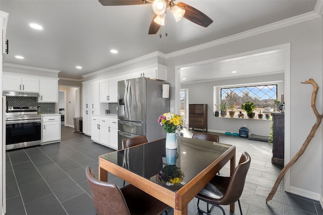 tiled dining space featuring ceiling fan and crown molding