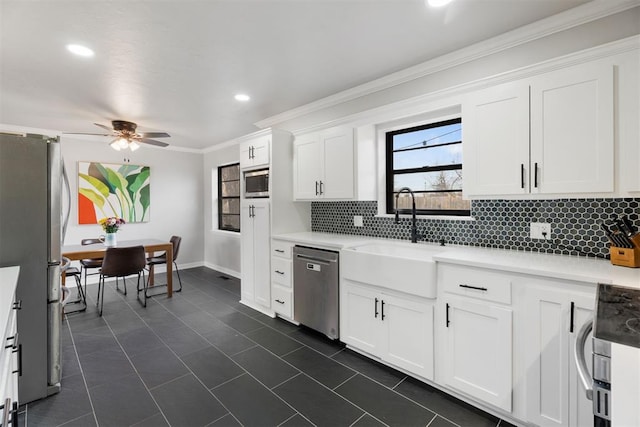 kitchen featuring white cabinets, ceiling fan, sink, and stainless steel appliances