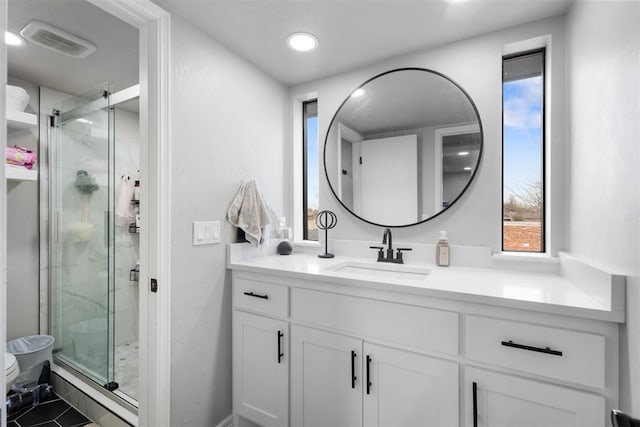 bathroom featuring tile patterned flooring, vanity, and a shower with shower door