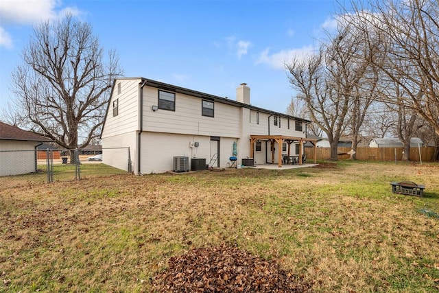 rear view of property featuring a yard, central AC, and a patio area