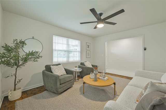 living room with dark parquet flooring and ceiling fan