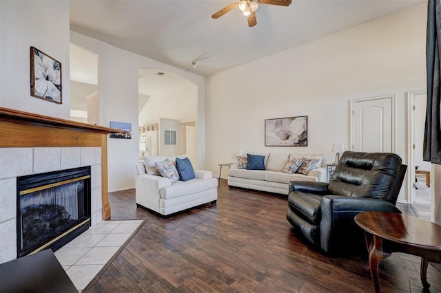 living room featuring a tiled fireplace, ceiling fan, and hardwood / wood-style flooring