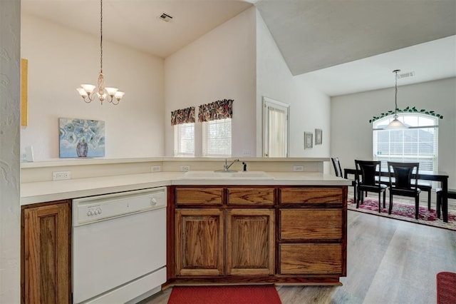 kitchen with sink, a notable chandelier, dishwasher, light hardwood / wood-style floors, and plenty of natural light