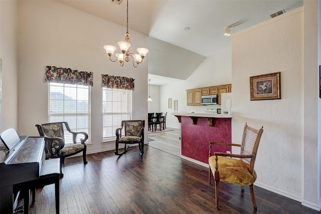 living area with dark hardwood / wood-style floors, vaulted ceiling, and a chandelier