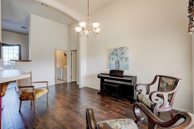 living area with a chandelier, dark hardwood / wood-style flooring, and washer and clothes dryer