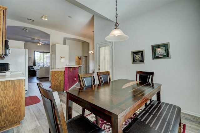 dining space with ceiling fan and light hardwood / wood-style flooring