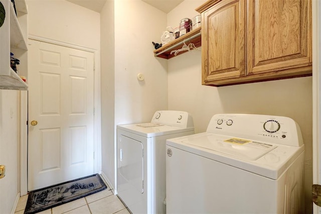 laundry area featuring independent washer and dryer, cabinets, and light tile patterned floors