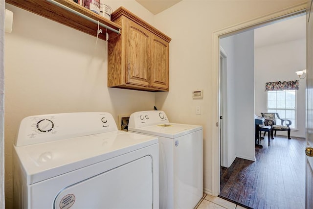 laundry area featuring cabinets, independent washer and dryer, and light tile patterned flooring