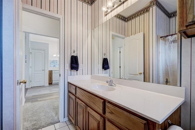 bathroom featuring tile patterned flooring, vanity, an inviting chandelier, and walk in shower