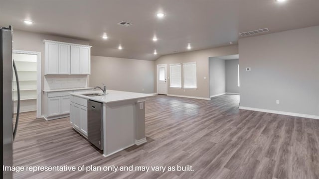13581 Hickory Way, Edmond, OK 73025 - kitchen with appliances with stainless steel finishes, a sink, open floor plan, light wood finished floors, and white cabinetry
