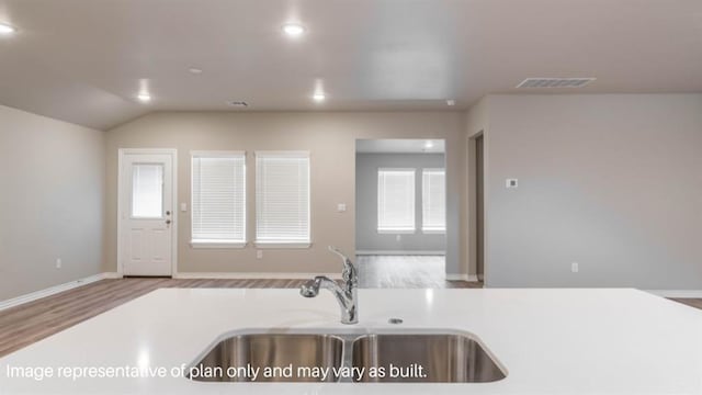 13581 Hickory Way, Edmond, OK 73025 - kitchen featuring a sink, wood finished floors, recessed lighting, light countertops, and baseboards