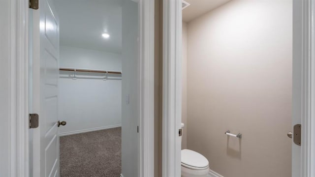 13581 Hickory Way, Edmond, OK 73025 - bathroom featuring toilet, baseboards, and a walk in closet