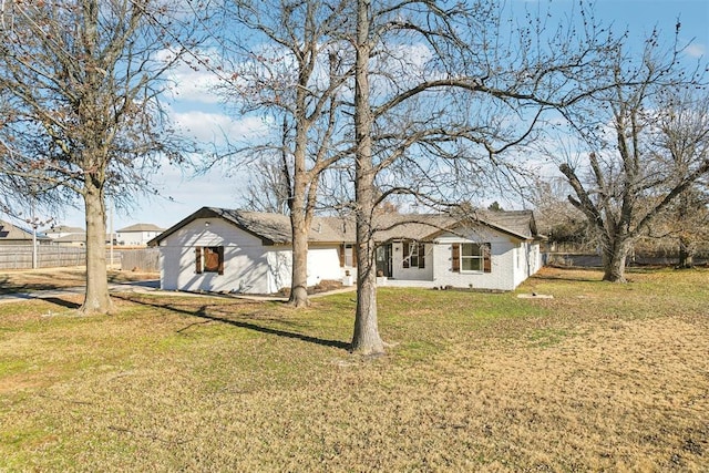 single story home with brick siding, fence, and a front yard