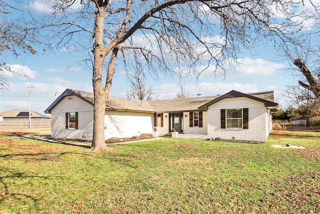 view of front of house featuring a front yard, fence, and brick siding