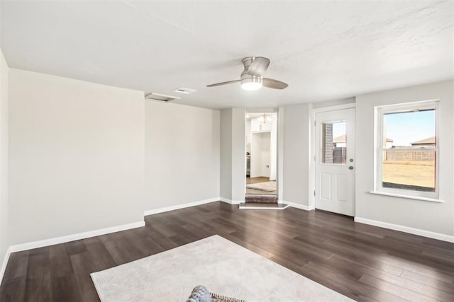 spare room with visible vents, dark wood-style flooring, a ceiling fan, and baseboards